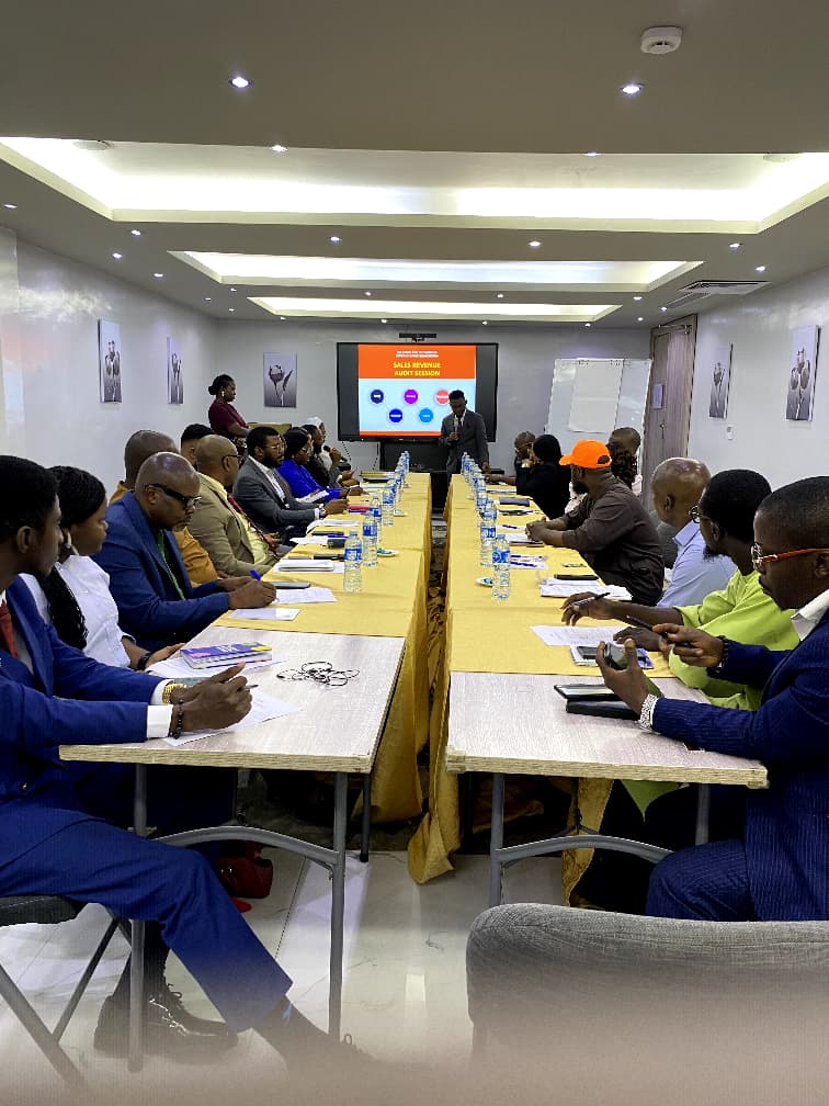 Coach Sam presenting the Sales Booster Center Lagos brochure